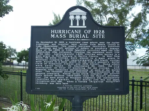 The historical marker at the 1928 mass burial site in West Palm Beach, mounted on a low stand.