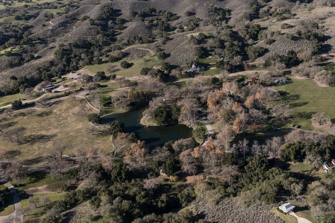 Aerial photograph of the Neverland Ranch estate spread across green hills in the Santa Ynez Valley, California.