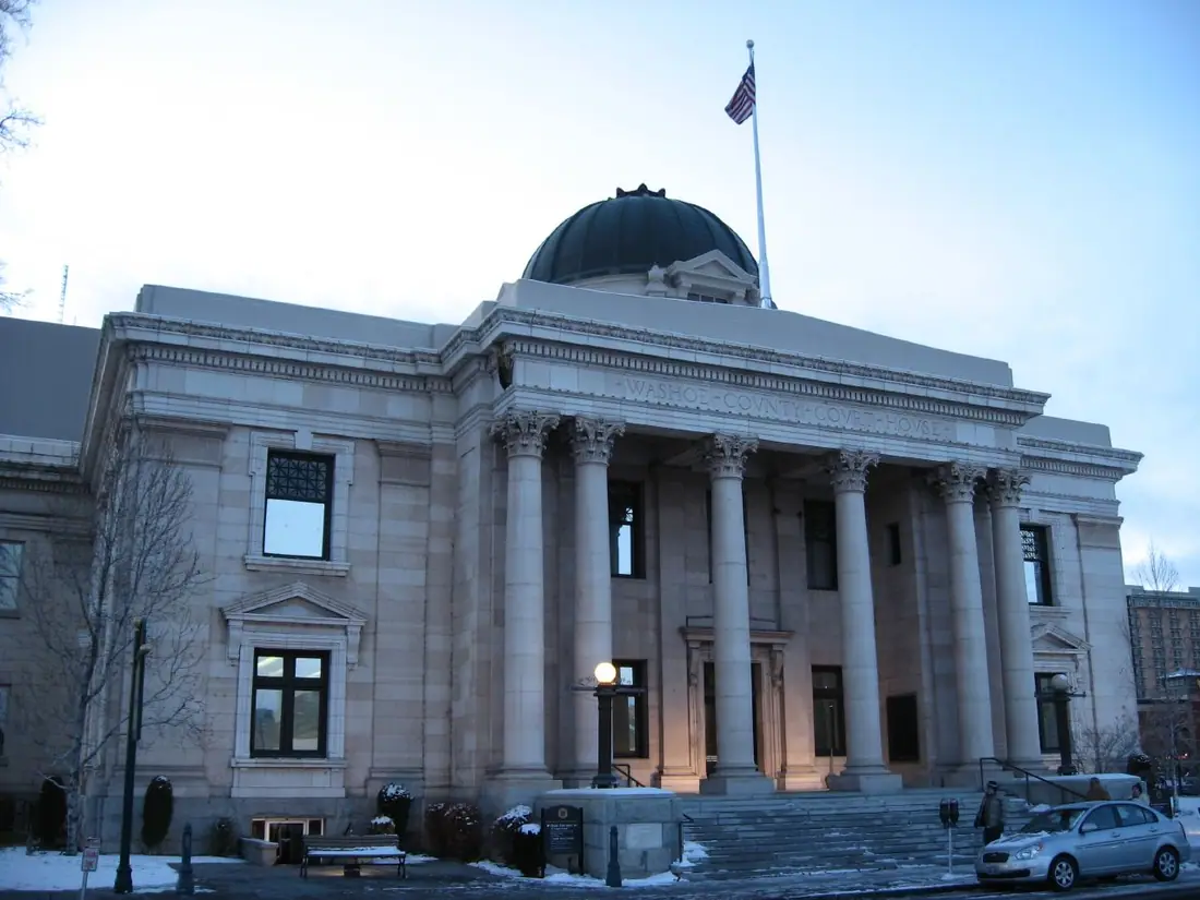 The domed neoclassical Washoe County Courthouse in Reno, Nevada, seen from the street behind a low wall and lamp posts.