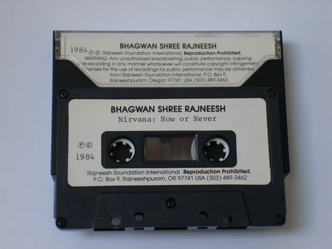 An audio cassette and its case as distributed at Rajneeshpuram in 1984, showing the printed copyright notice.
