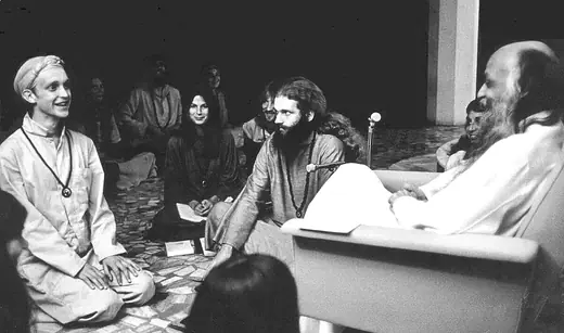 Rajneesh seated with followers gathered around him at Poona in 1977.