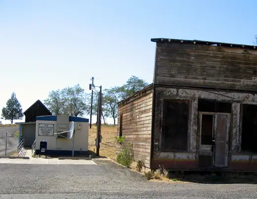 Small white clapboard post office building in Antelope, Oregon, under a clear sky.