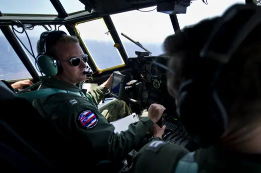 A Coast Guard HC-130 Hercules flying low over open ocean off the coast of Oahu during a search and rescue training mission.