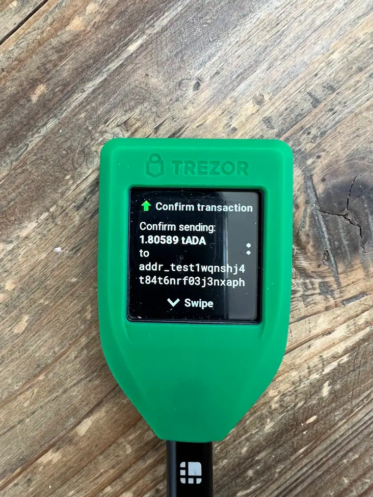 A Trezor Model T hardware wallet standing upright, its small colour screen facing the camera.