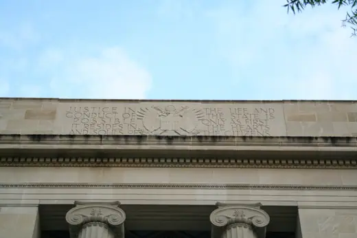 A carved stone inscription on the exterior of the Robert F. Kennedy Department of Justice Building.