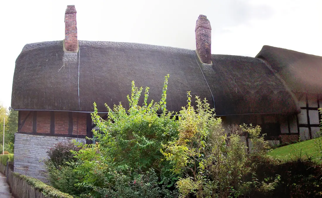 Timber-framed thatched farmhouse with a cottage garden in the foreground, Anne Hathaway's Cottage at Shottery.