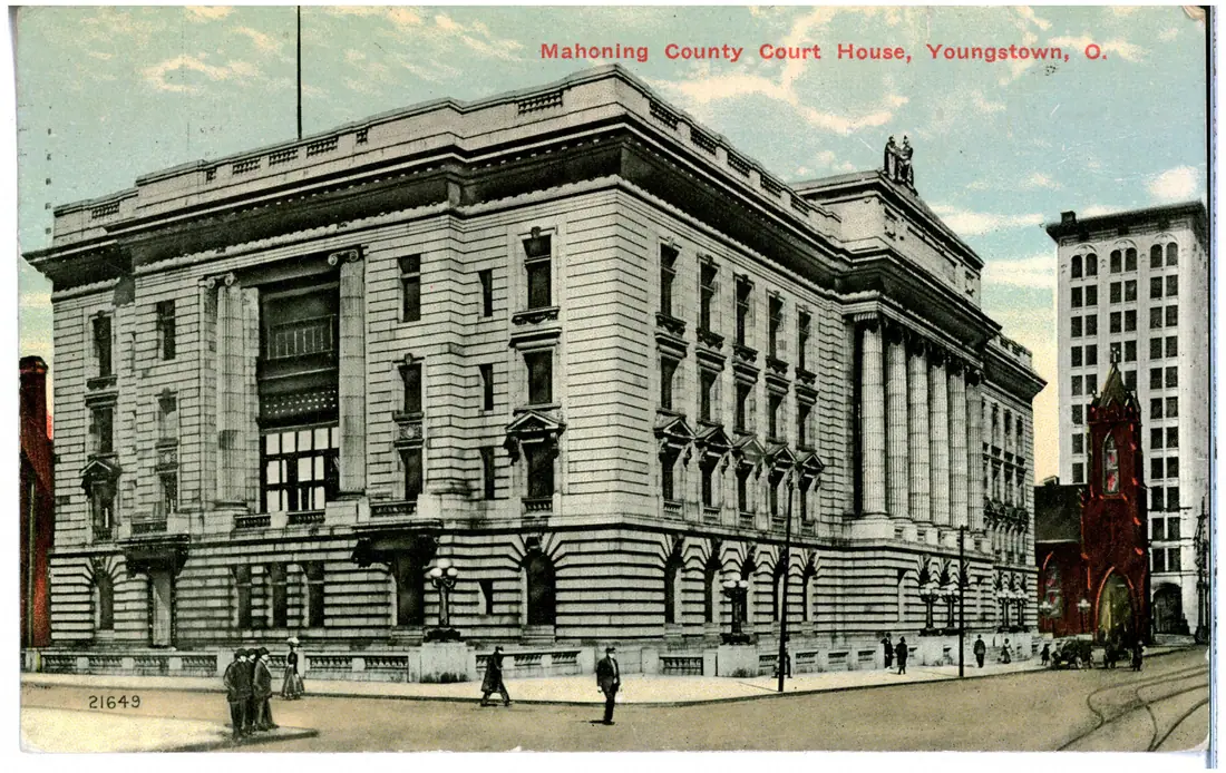 A colour-printed postcard view of the Mahoning County Court House in Youngstown, Ohio, with trees and a street in the foreground.