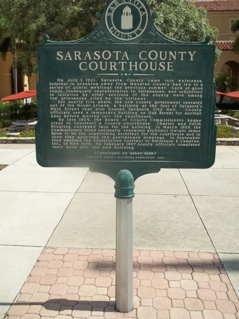 The Mediterranean Revival tower of the Sarasota County Courthouse against a blue sky.