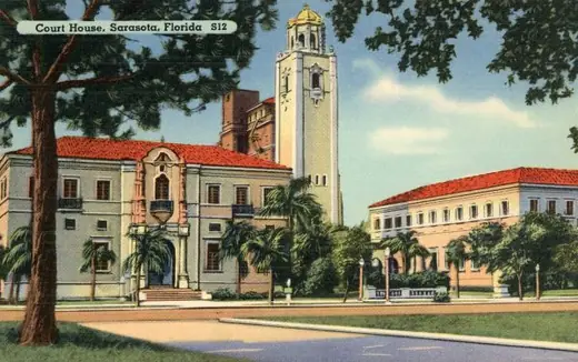 A hand-coloured postcard of the Sarasota County Courthouse in the early twentieth century.