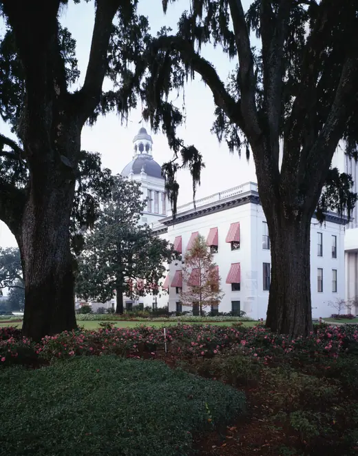 Florida's white historic capitol building with red-and-white striped awnings and a domed cupola.