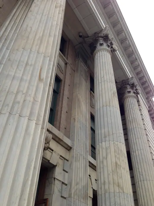 A row of tall stone columns along the front of the Tampa federal courthouse.