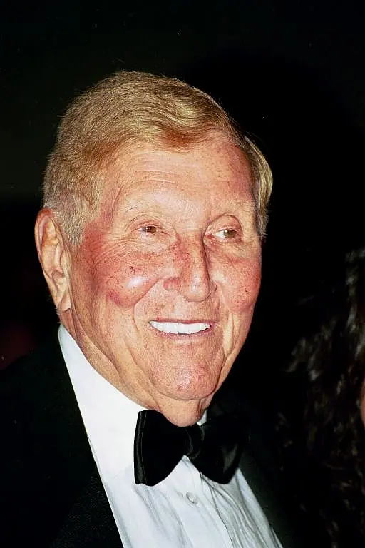 Sumner Redstone in a dark suit and bow tie, photographed at a public event.