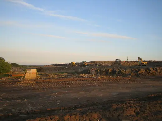 The active face of a British municipal landfill site seen from a footpath.