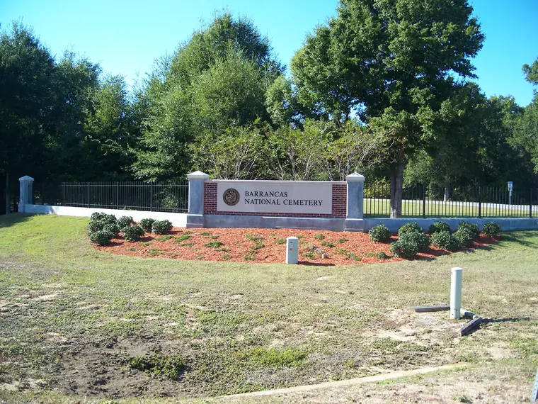 The stone entrance sign for Barrancas National Cemetery in Pensacola, Florida.