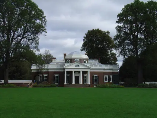 Photograph of Monticello's neoclassical west front with its dome and portico, seen across the lawn.