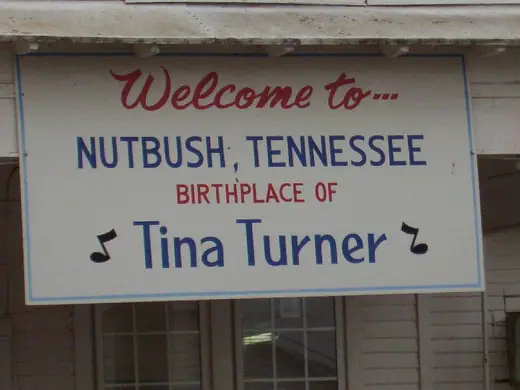 A sign reading Welcome to Nutbush, Tennessee, Birthplace of Tina Turner, outside a grocery store.