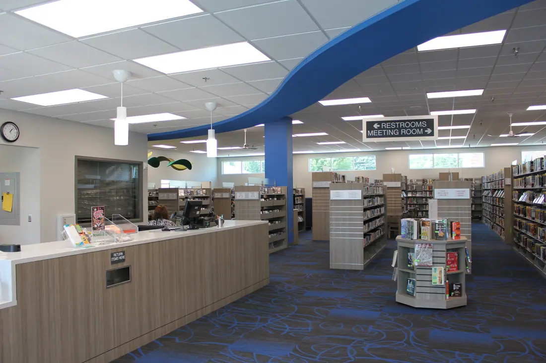 Interior reading room of the Le Mars Public Library, with shelving and study tables.