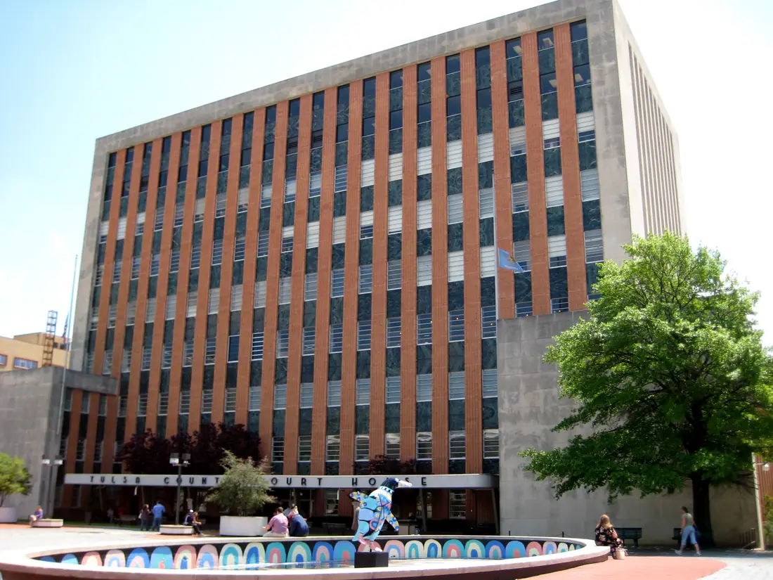The Tulsa County Courthouse, a mid-century stone-and-glass civic building seen from the street.