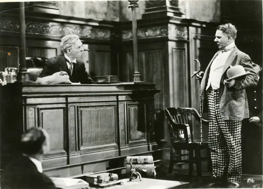 Film still of a comedian in costume at a fairground, 1925.