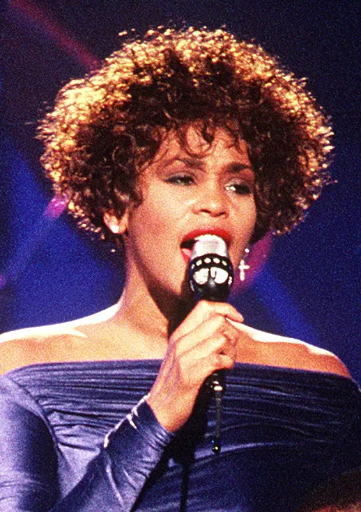 Whitney Houston singing at a microphone during the Welcome Home Heroes concert for Operation Desert Storm troops, March 1991.